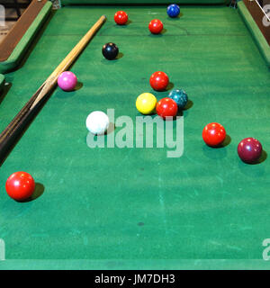 old snooker balls and cue on snooker table Stock Photo