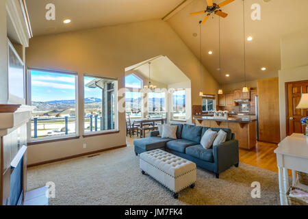 Large living or great room in a residential home with vaulted ceilings formal dining and view from a wall of windows Stock Photo