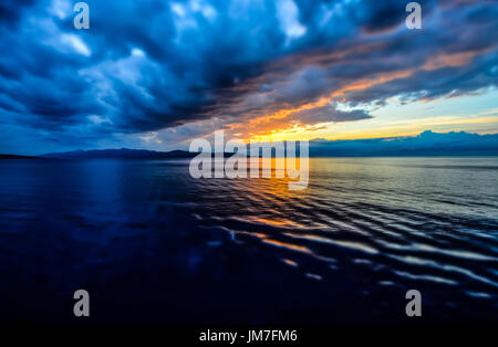 Sunset off the coast of Sicily Italy as clouds come in along with an approaching storm Stock Photo