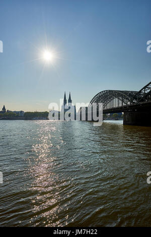 Cologne Cathedral in view past Hohenzollern Bridge as seen from Kennedy Ufer/ riverbank Stock Photo