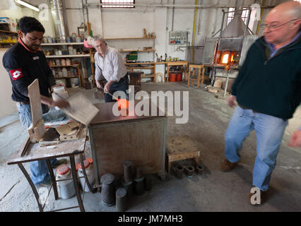 The glassblowers work in their workshop on Murano island, Venice, Italy Stock Photo