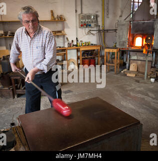 The glassblowers work in their workshop on Murano island, Venice, Italy Stock Photo