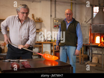 The glassblowers work in their workshop on Murano island, Venice, Italy Stock Photo