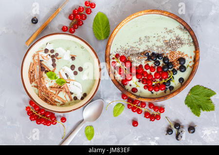 Green smoothies bowls with berries and chocolate. Love for a healthy vegan food concept. Stock Photo