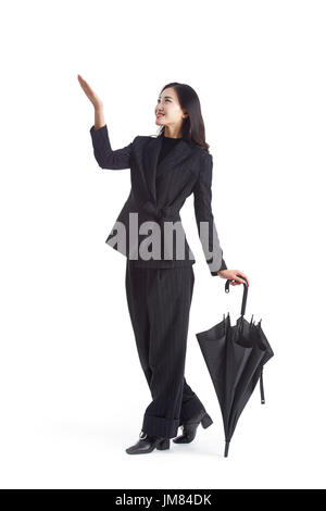 young asian businesswoman with folded black umbrella, studio shot, isolated on white background. Stock Photo