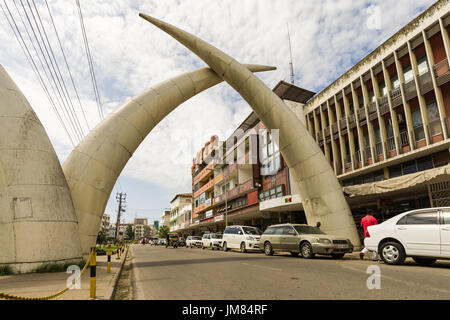 Aluminium Elephant Tusks Above Moi Avenue In Mombasa With Local Buildings In Background, Kenya Stock Photo