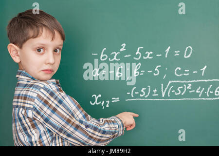 Lagging learner at the blackboard looking for a hint Stock Photo