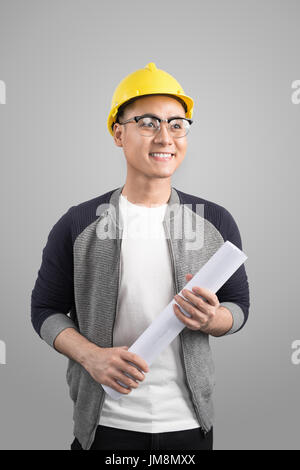 Handsome civil engineer working with documents on gray background Stock Photo