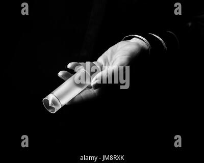 Black Mania. woman hand isolated on black showing sample jar Stock Photo