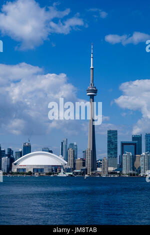 The CN Tower and Rogers Centre Center dominate the Toronto skyline seen from the Toronto Island ferry on a sunny day. Vertical format with copy space. Stock Photo