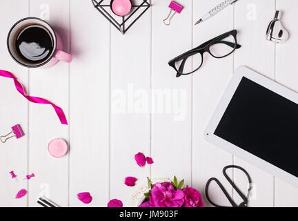 Modern woman's workplace with tablet, coffee, glasses  and other small accessories Stock Photo