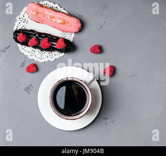 Delicious eclairs and coffee, top view Stock Photo