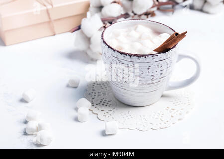 Hot cocoa in a cup with marshmallows and cinnamon on marble table close-up Stock Photo