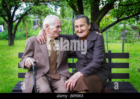 Cute 80 plus year old married couple posing for a portrait in their garden. Love forever concept. Stock Photo