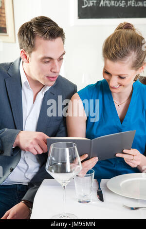 Couple is reading the menu together in a restaurant
