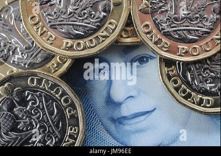 NEW ONE POUND COINS WITH QUEENS HEAD ON NEW FIVE POUND NOTE RE FINANCE BREXIT SAVERS SAVINGS HOUSEHOLD BUDGETS INFLATION INVESTMENTS MONEY WAGES UK Stock Photo