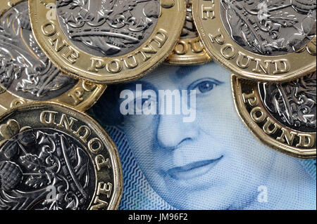 NEW ONE POUND COINS WITH QUEENS HEAD ON NEW FIVE POUND NOTE RE FINANCE BREXIT SAVERS SAVINGS HOUSEHOLD BUDGETS INFLATION INVESTMENTS MONEY WAGES UK Stock Photo