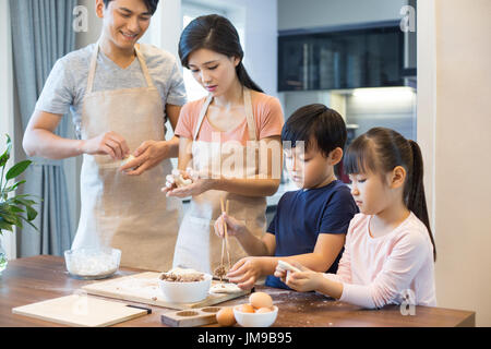 Happy young Chinese family baking together Stock Photo