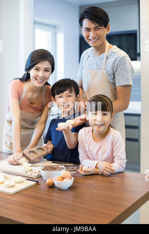 Happy young Chinese family baking together Stock Photo