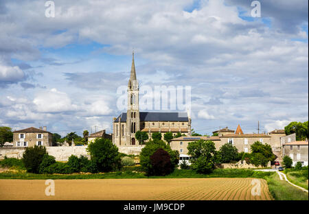 View towards Church of St Saturnin, Beguey and Cadillac, communes in the Gironde department in Nouvelle-Aquitaine, southwestern France, across fields Stock Photo