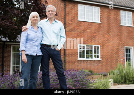 Portrait Of Retired Couple Standing Outside Home Stock Photo