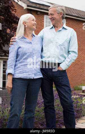Retired Couple Standing Outside Home Stock Photo