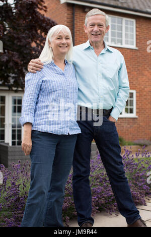 Couple Standing Outside House With Real Estate Sign Stock Photo - Alamy