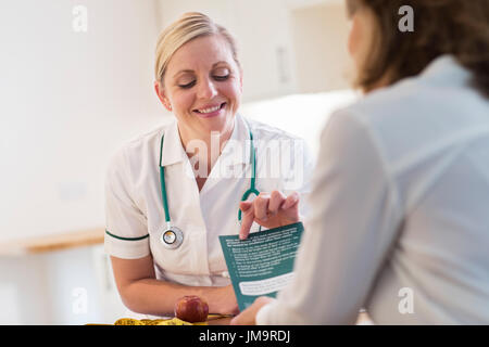 Mature Woman Meeting With Dietician In Doctors Office Stock Photo
