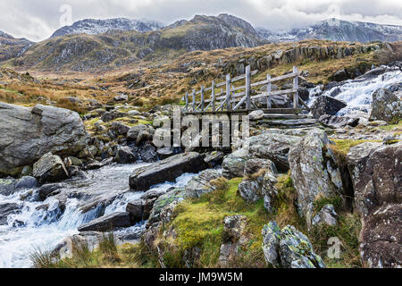 Bridge across waterfall near Llyn Ogwen on the path to Llyn Idwal and the Devil's Kitchen in the Glyderau mountain range Snowdonia North Wales UK Stock Photo
