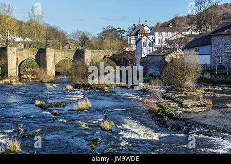 River Dee flowing through the centre of Llangollen showing the Dee Bridge a scheduled ancient monument Denbighshire Wales UK March 3095 Stock Photo
