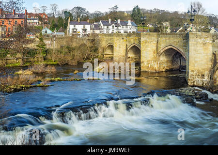 River Dee flowing through the centre of Llangollen showing the Dee Bridge a scheduled ancient monument Denbighshire Wales UK March 3315 Stock Photo