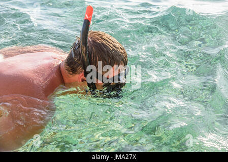 Man in a diving mask in sea water. Stock Photo