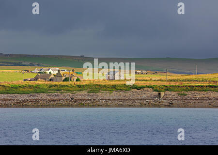 Landscape at Burwick, South Ronaldsay / Orkney Islands. As seen from ferry, approaching Burwick. Cloudy day with rays of sunlight. Stock Photo