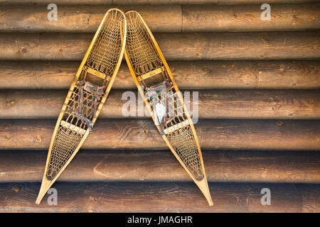 Antique Wooden Snow Shoes Mounted on Log Cabin Wall Stock Photo