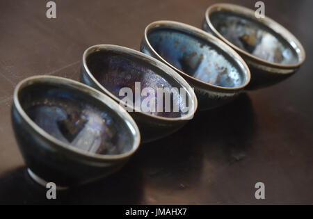 (170726) -- JIANYANG, July 26, 2017 (Xinhua) -- Works by Lu Jinxi, a Jian ware porcelain craftsman, are displayed in a workshop in Jianyang District of Nanping City, southeast China's Fujian Province, July 25, 2017. The jian ware porcelain, flourished in Song Dynasty (960-1279), famous for its golden black glaze with streaks of 'hare's fur', is revived in recent decades after 600 years of disappearance of the knowhow of its manufacture. Lu Jinxi, 45, is one of the first craftsmen who rediscovered the long-lost art of the making of the heritage crafts.  (Xinhua/Song Weiwei) (clq)(zt) Stock Photo