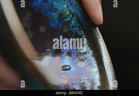 (170726) -- JIANYANG, July 26, 2017 (Xinhua) -- Lu Jinxi, a Jian ware porcelain craftsman, examines a porcelain bowl in a workshop in Jianyang District of Nanping City, southeast China's Fujian Province, July 25, 2017. The jian ware porcelain, flourished in Song Dynasty (960-1279), famous for its golden black glaze with streaks of 'hare's fur', is revived in recent decades after 600 years of disappearance of the knowhow of its manufacture. Lu Jinxi, 45, is one of the first craftsmen who rediscovered the long-lost art of the making of the heritage crafts.  (Xinhua/Song Weiwei) (clq)(zt) Stock Photo