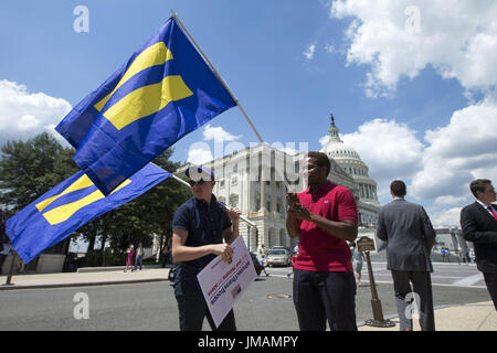 July 26, 2017 - Washington, District Of Columbia, U.S.- BEN CHRISTANSON (l) of Iowa and PAUL LISBEN (r) of Kansas City hold equality flags on the U.S. Capitol Plaza shortly after president Trump tweeted that transgender people can no longer serve in the military. Credit: Alex Edelman/ZUMA Wire/Alamy Live News Stock Photo