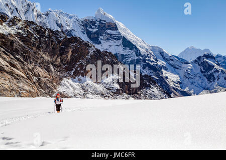 Hiking Woman Crossing Cho La Pass. Himalaya Beautiful Mountain Peaks, Inspirational Autumn Himalayas Landscape in Everest National Park, Nepal. Stock Photo