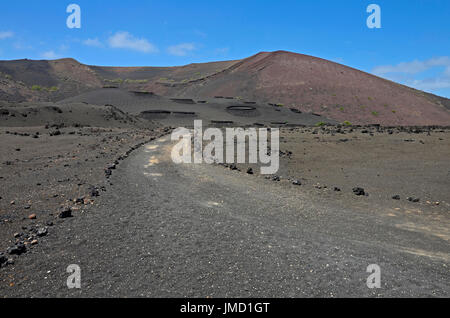A trekking route with a view to volcanic mountains in Timanfaya National Park on Lanzarote,  the Canary Islands Stock Photo
