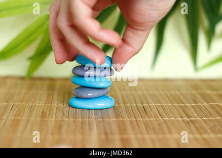 A hand that features pebbles in Zen lifestyle on a brown bamboo floor Stock Photo