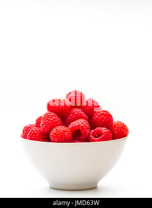 A white bowlful of fresh, organic, juicy raspberries on an isolated white background with copy space. Stock Photo