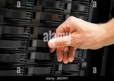 Computer Technician's Hand Replacing Hard Drive In San Stock Photo