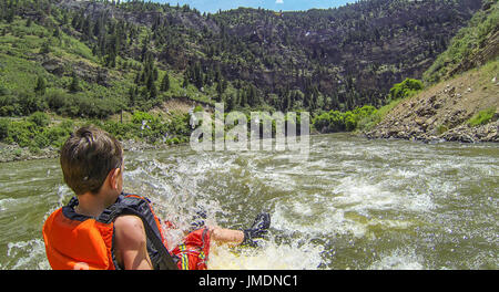 A young boy rides the bull during a white water rafting expedition on the Colorado River in Glenwood Canyon Stock Photo