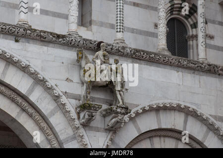 Italy, Lucca - September 18 2016: the view of the statue of Saint Martin shares his cloak with a beggar. Lucca Cathedral. Cattedrale di San Martino on Stock Photo