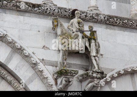 Italy, Lucca - September 18 2016: the view of the statue of Saint Martin shares his cloak with a beggar. Lucca Cathedral. Cattedrale di San Martino on Stock Photo