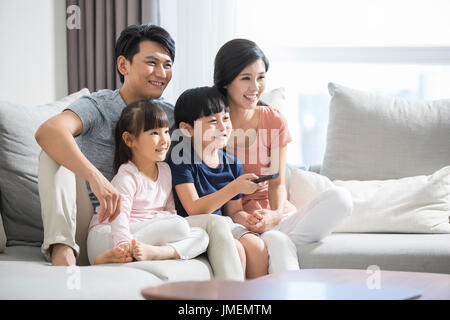 Happy young Chinese family watching TV Stock Photo - Alamy