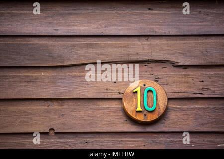 Road sign on a house reading the number ten made out of wood Stock Photo