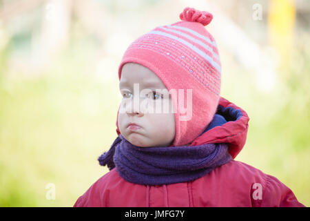 brown eyed girl child is looking left with red jumper Stock Photo