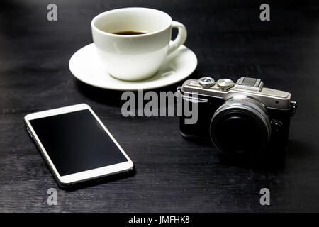 Coffee with camera and mobile phone on wood background. Stock Photo