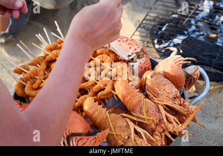 Vietnamese seefood grilled on fire at directly at the beach in Nha Trang, Vietnam. Stock Photo